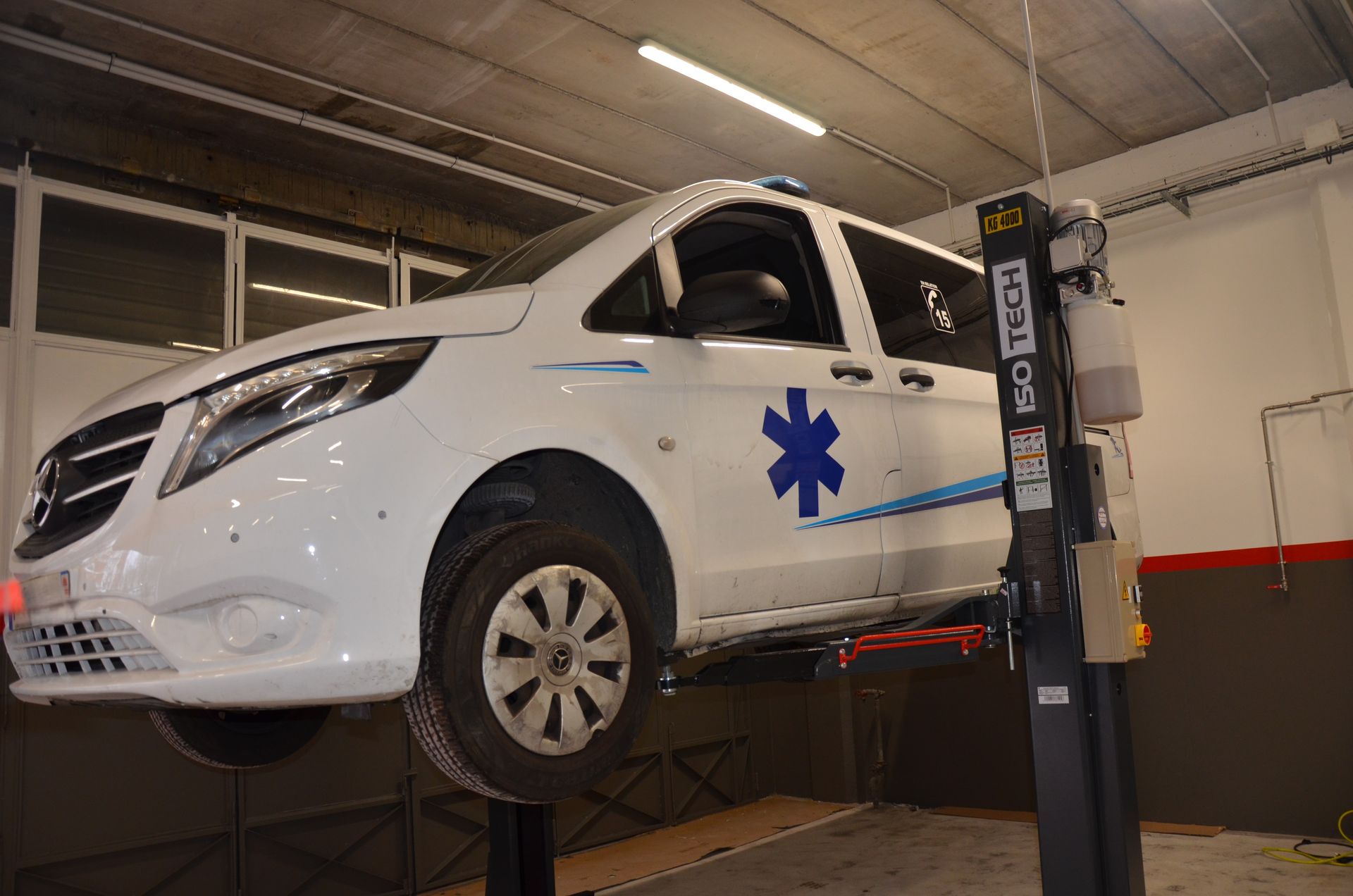 Ambulance à l'atelier de mécanique, pont élévateur