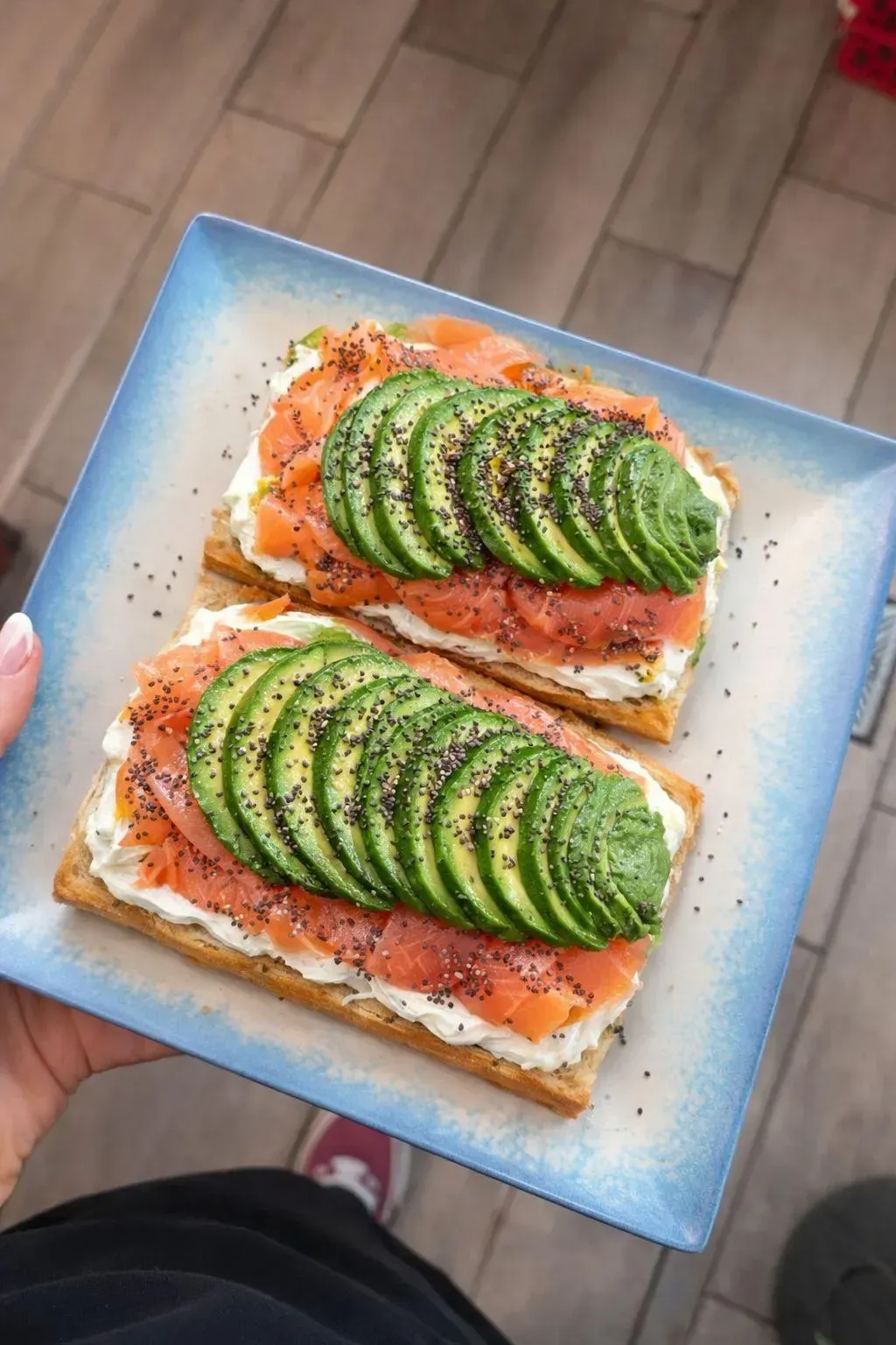 Dos rebanadas de pan tostado con aguacate sobre un plato azul