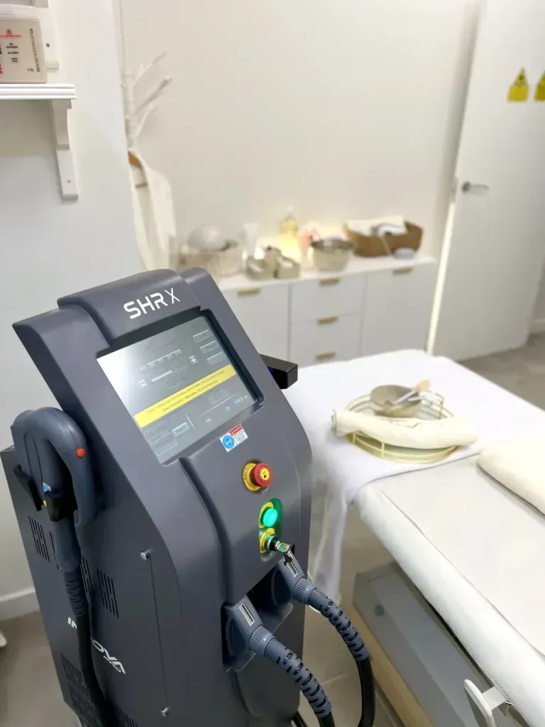 Mujer con diadema y bata blancas, acostada con los ojos cerrados, probablemente sometiéndose a un tratamiento facial.