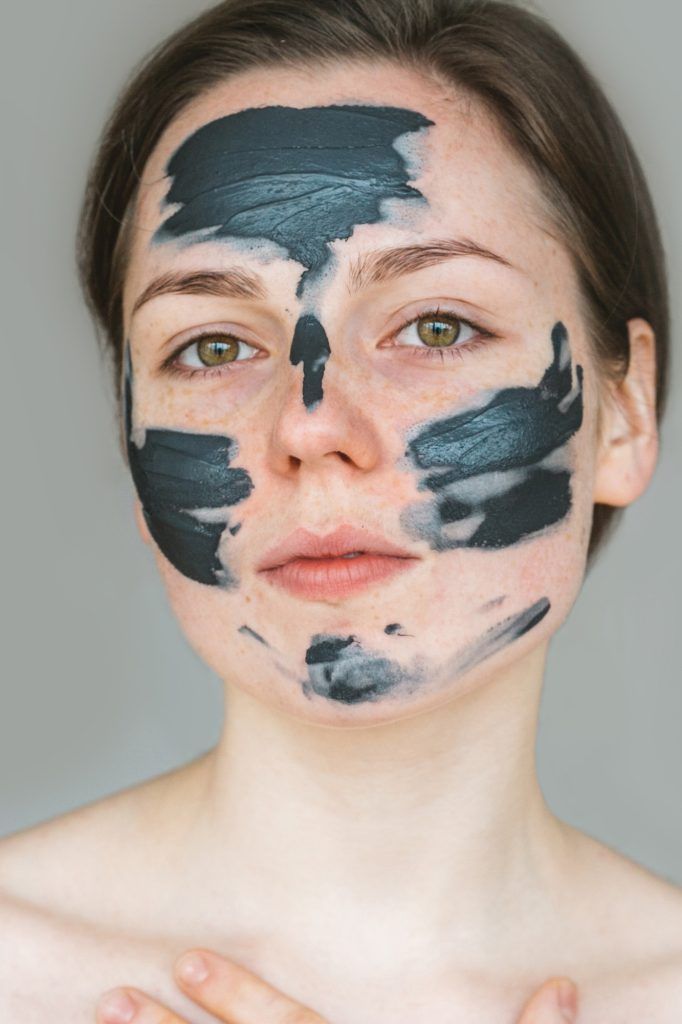 Mujer con diadema y bata blancas, acostada con los ojos cerrados, probablemente sometiéndose a un tratamiento facial.