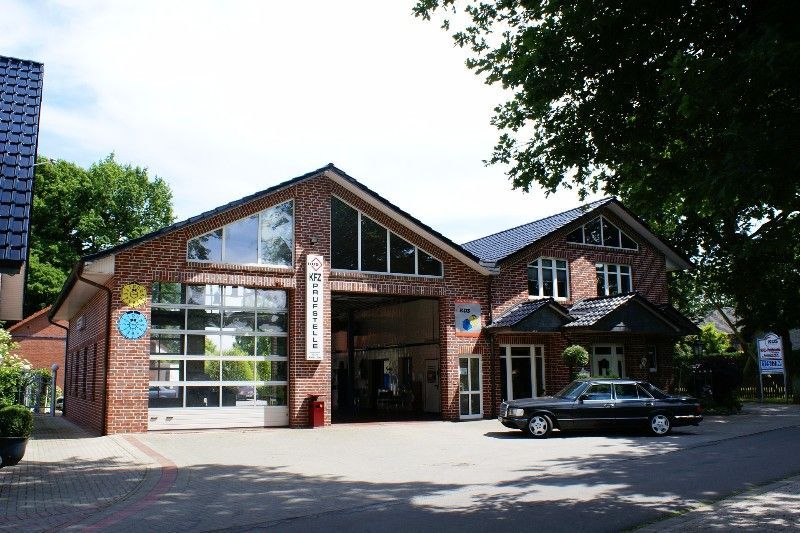 Ein großes Backsteingebäude mit einem davor geparkten Auto