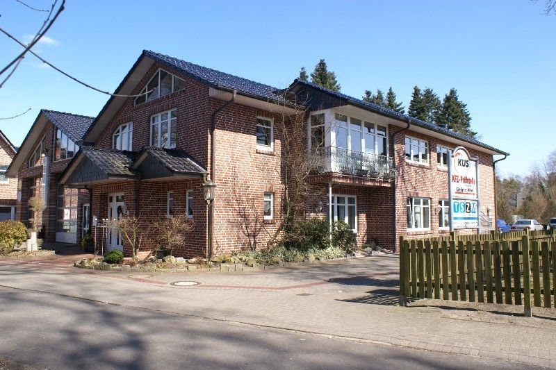 Ein großes Backsteingebäude mit einem Zaun davor