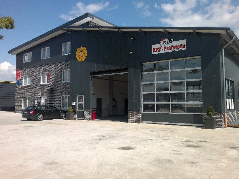 Ein schwarzes Auto steht vor einem großen Gebäude