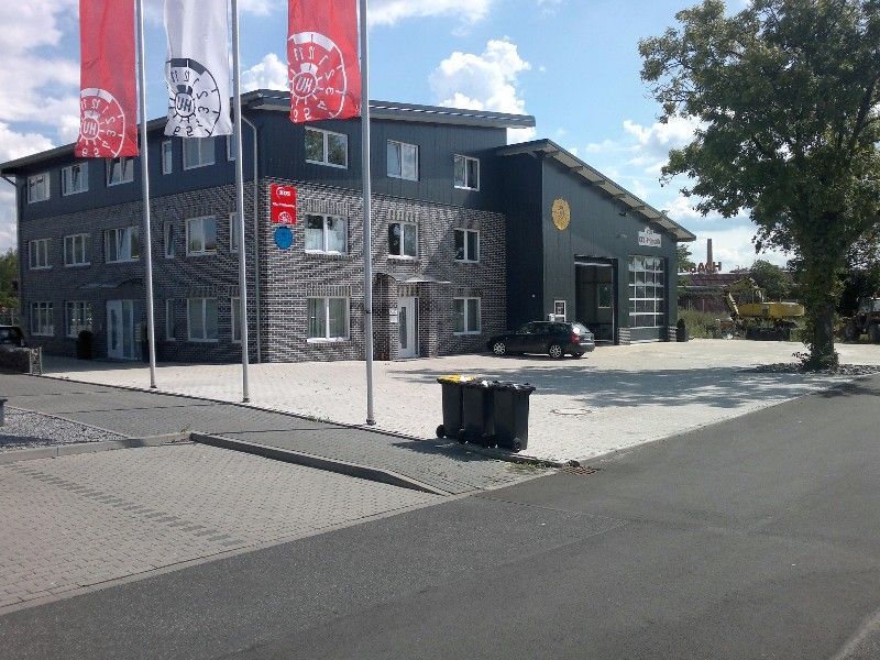 Ein großes Backsteingebäude mit einem davor geparkten Auto