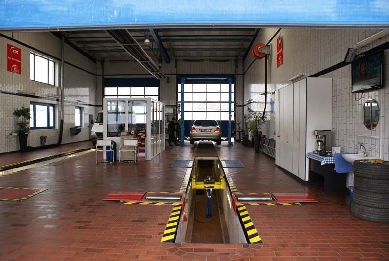 Ein Auto steht mit geöffneter Tür in einer Garage.