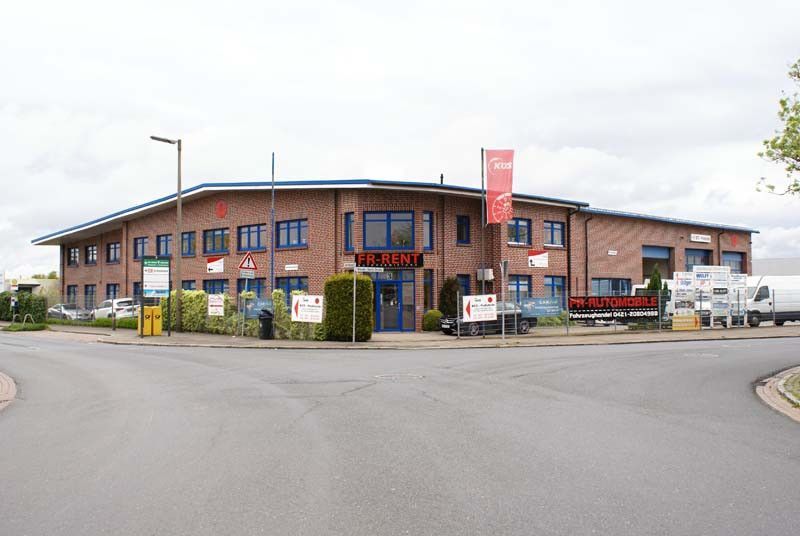 Ein großes Backsteingebäude mit einem roten Schild mit der Aufschrift „Willkommen“