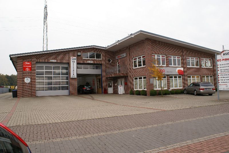 Ein großes Backsteingebäude mit davor geparkten Autos