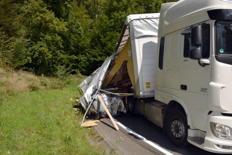 Ein weißer Lastwagen parkt am Straßenrand neben einem Zelt.