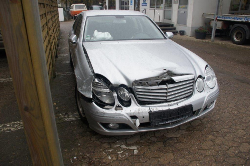 Ein silbernes Auto mit beschädigter Frontpartie steht auf einem Parkplatz