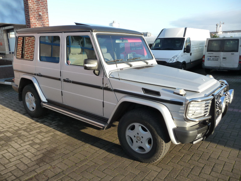 Ein weißer Jeep steht auf einer Ziegelsteinstraße