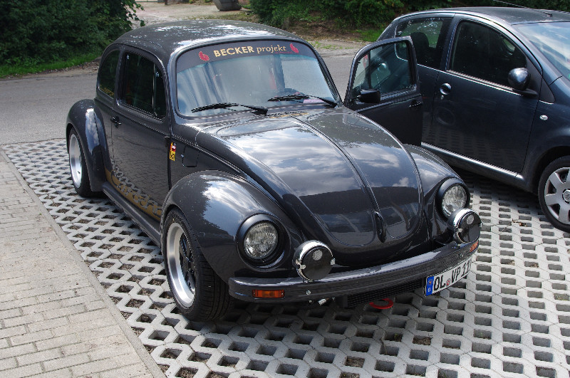 Ein schwarzes Auto steht auf einem Parkplatz neben einem anderen Auto