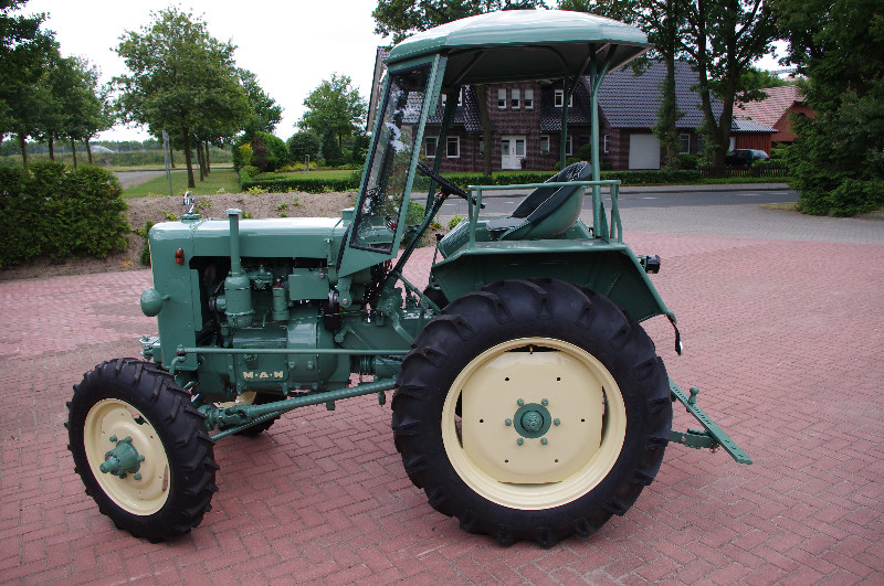Ein grün-weißer Traktor steht am Straßenrand