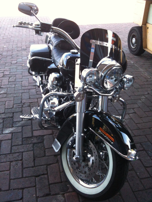 Ein schwarzes Harley-Davidson-Motorrad steht auf einer gepflasterten Auffahrt