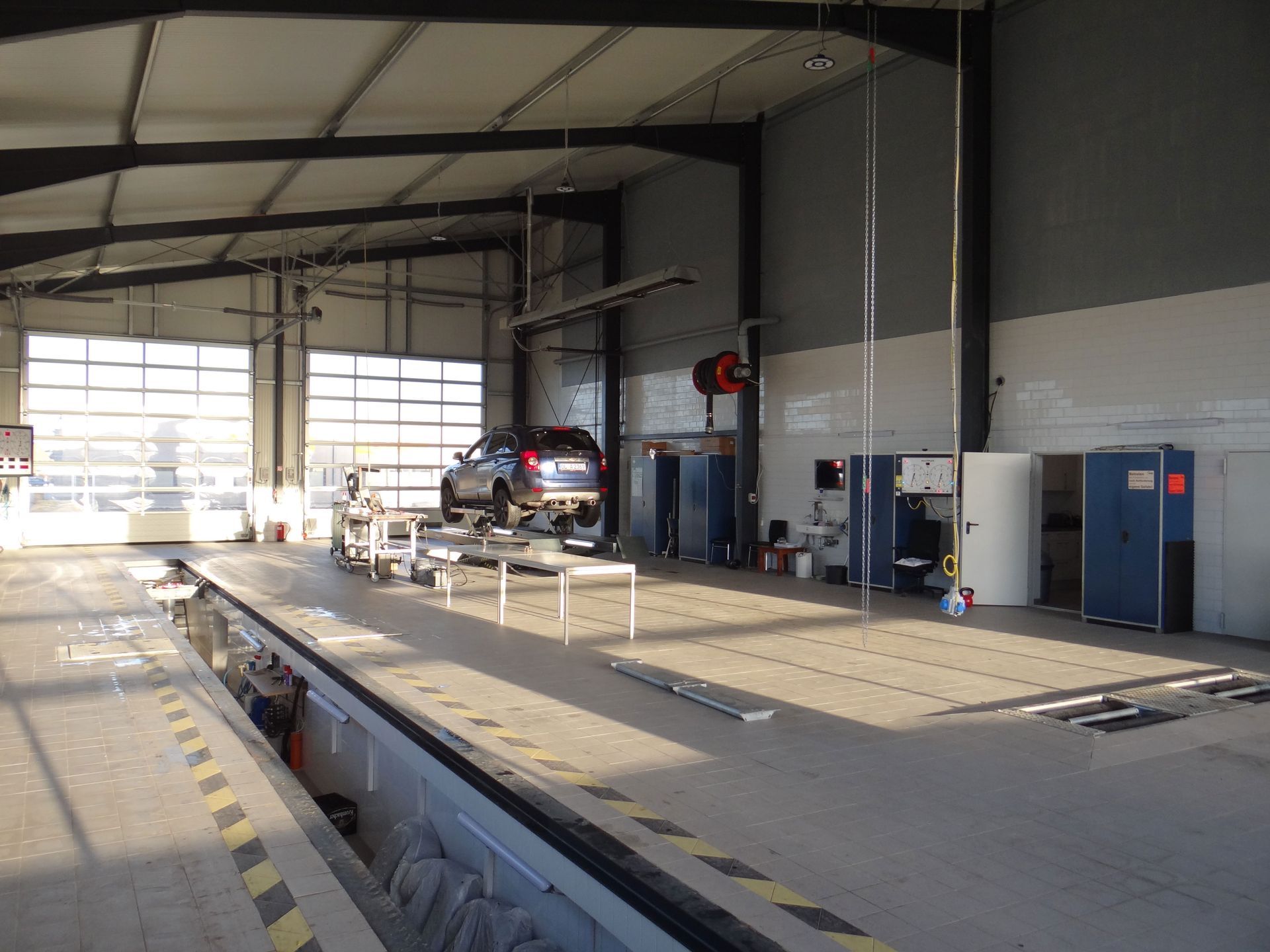 Ein Auto steht auf einer Hebebühne in einer Garage.