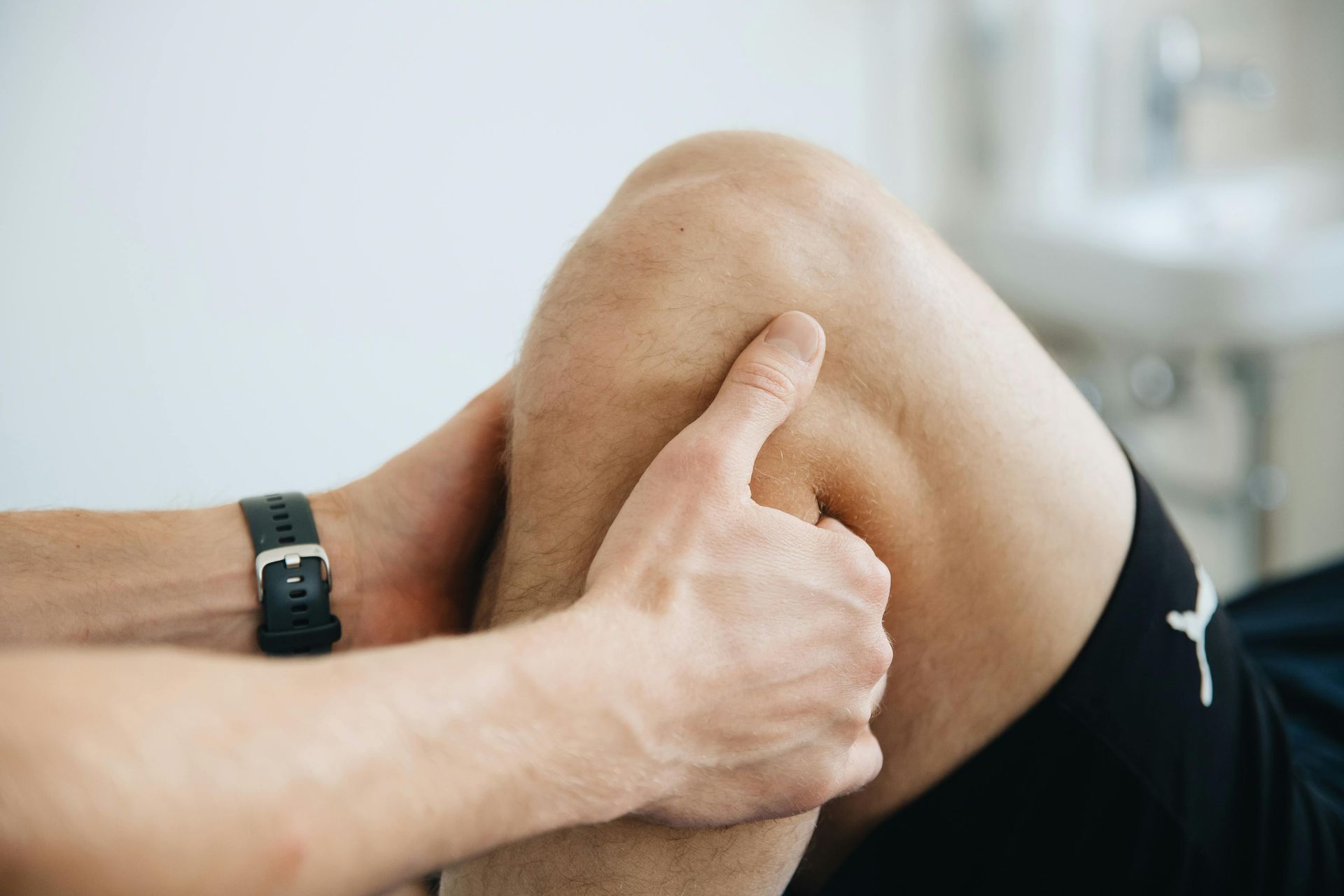Eine Person massiert das Knie einer anderen Person.