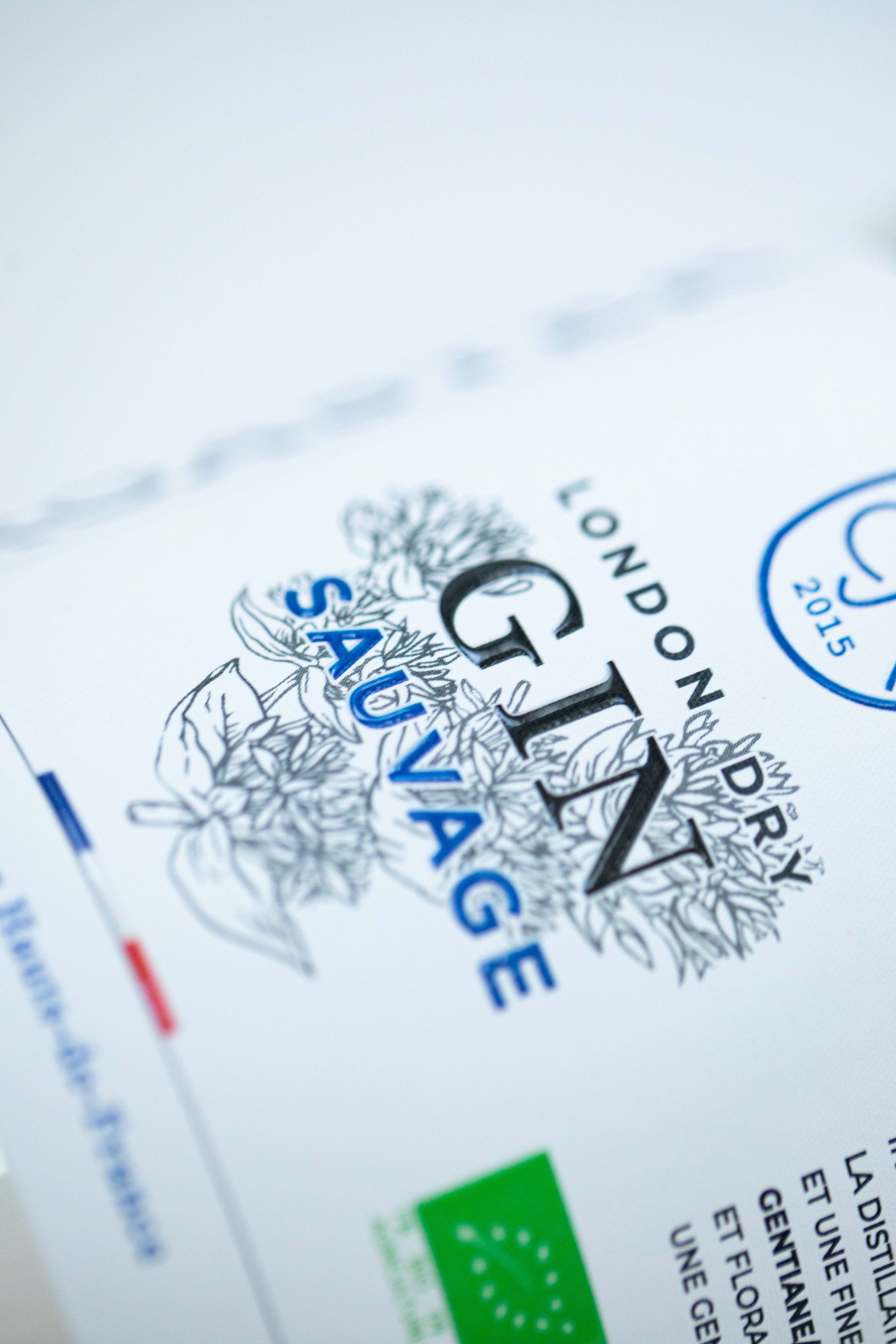 Support de communication autocollant sur bouteille de gin.