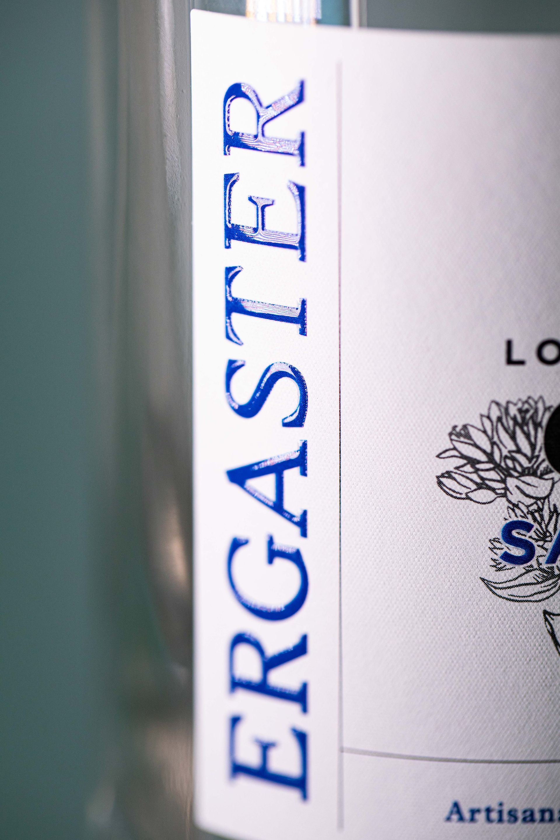 Support de communication autocollant blanc sur bouteille de spiritueux.