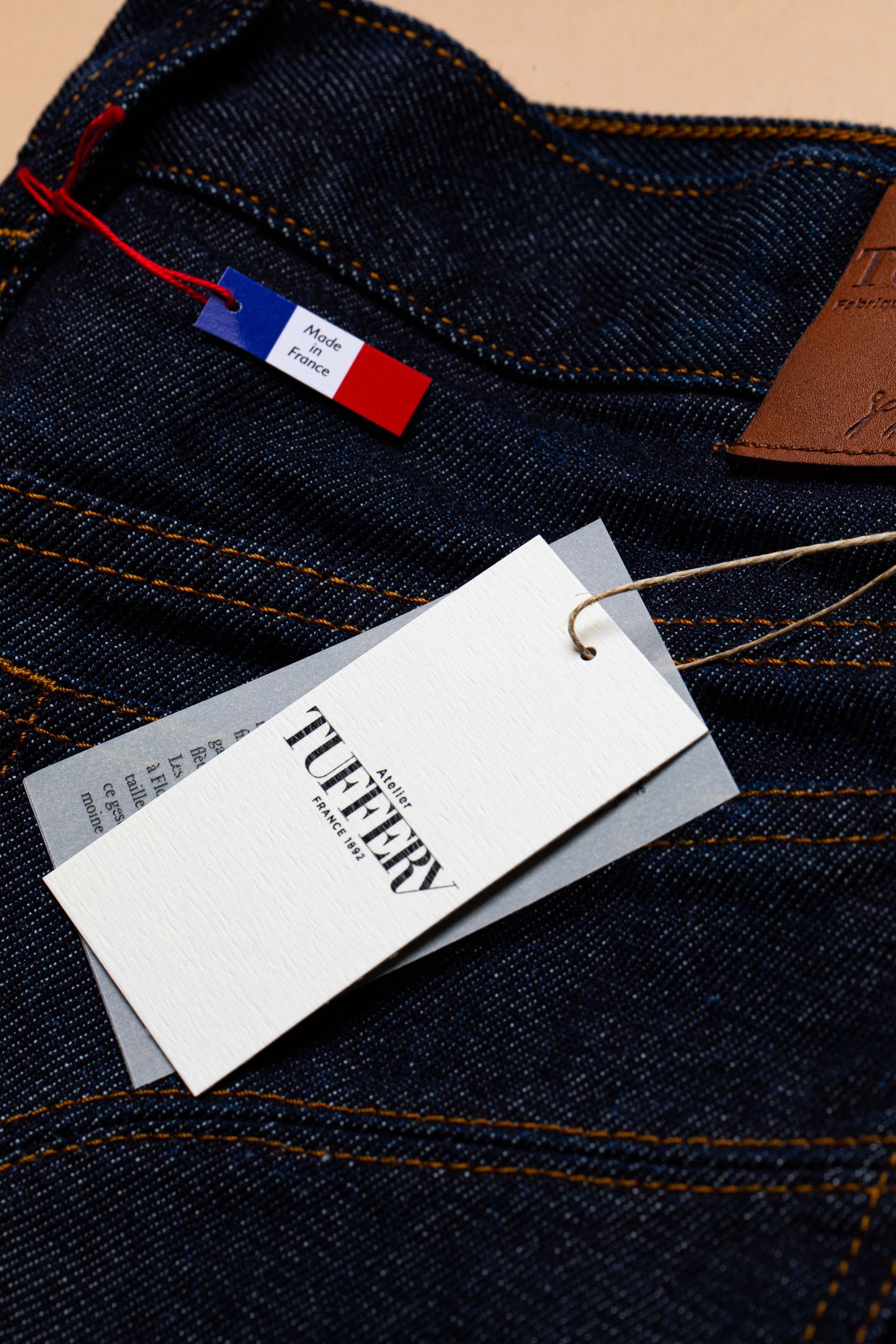 Étiquette à fil blanche sur jean noir.