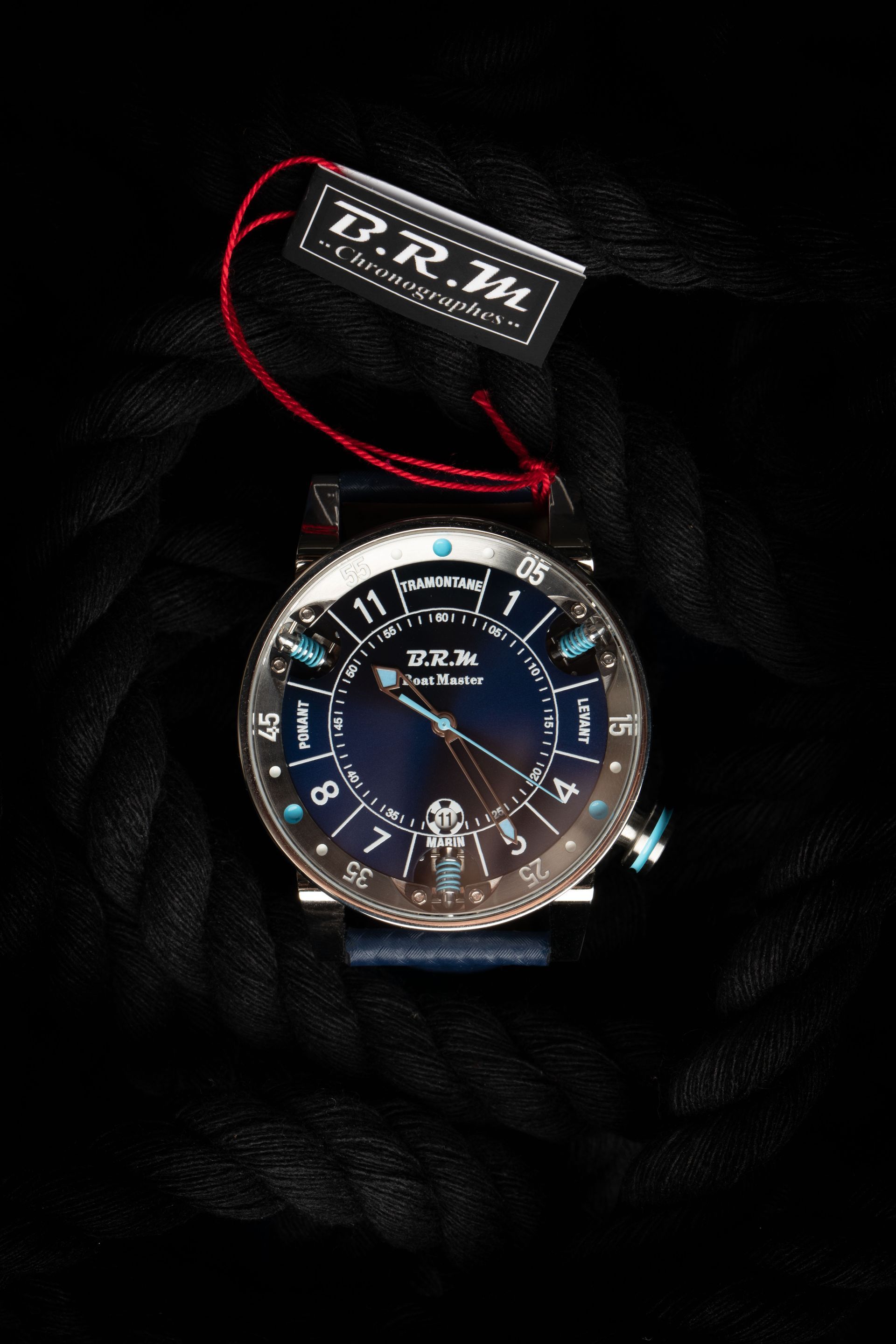 Montre-bracelet de luxe avec cadran bleu foncé et étiquette attachée sur un cordon noir