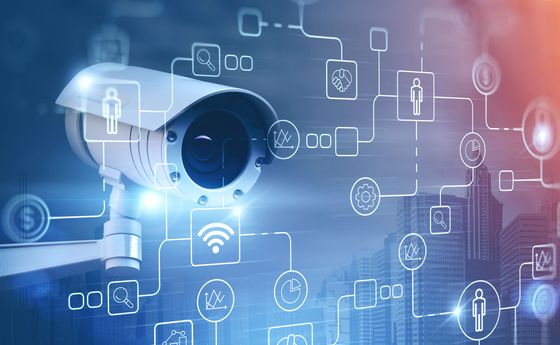Caméra de sécurité avec icônes numériques superposées sur un fond bleu technologique.