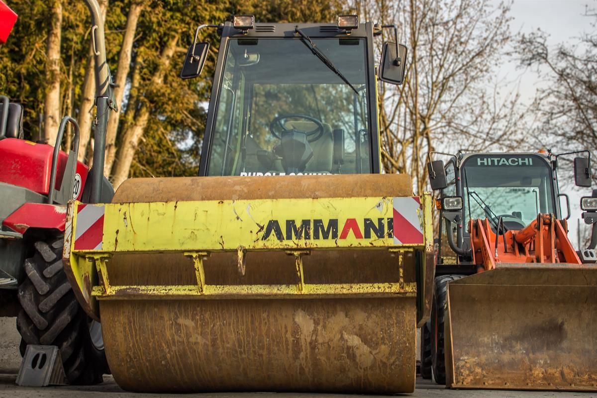 Ein gelber Amman-Traktor steht neben einem roten Traktor