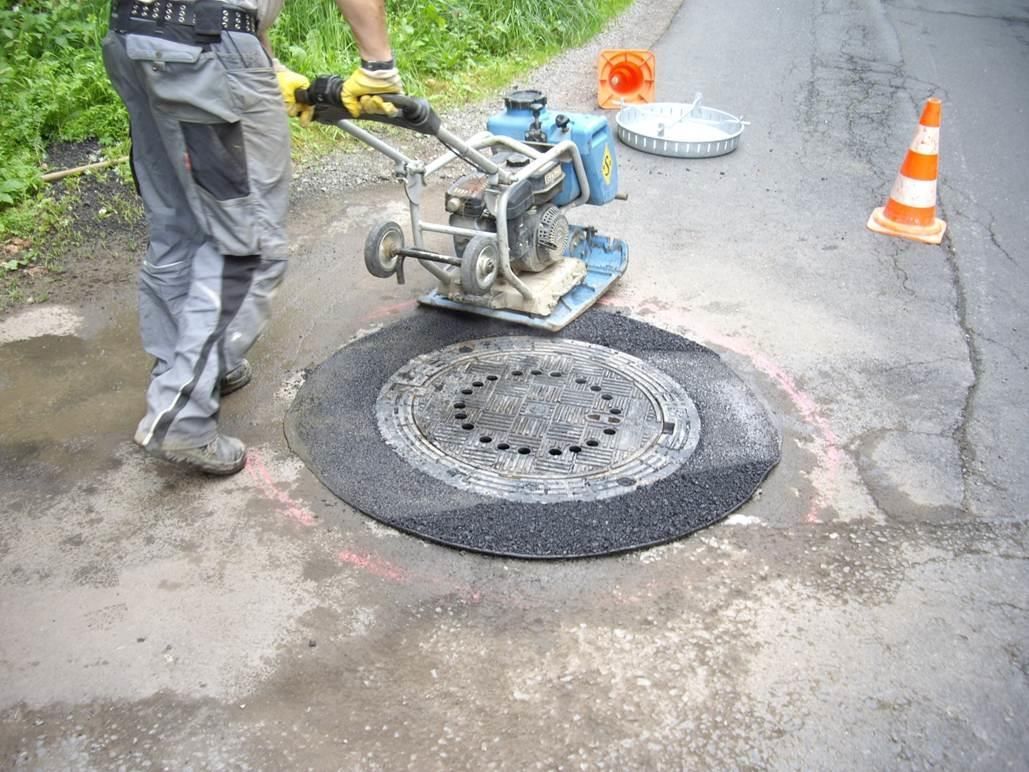 Abrütteln und planieren des neu eingefassten Kanaldeckels