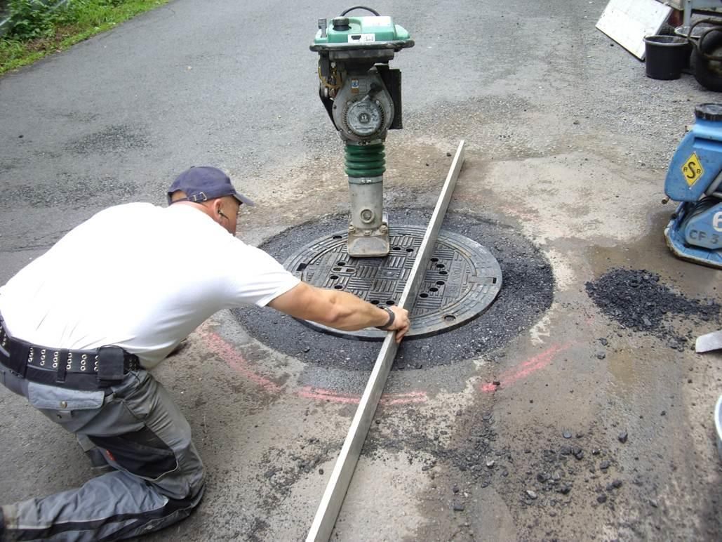 Anpassen der Einfassung und des Kanaldeckels an die Straßenebene