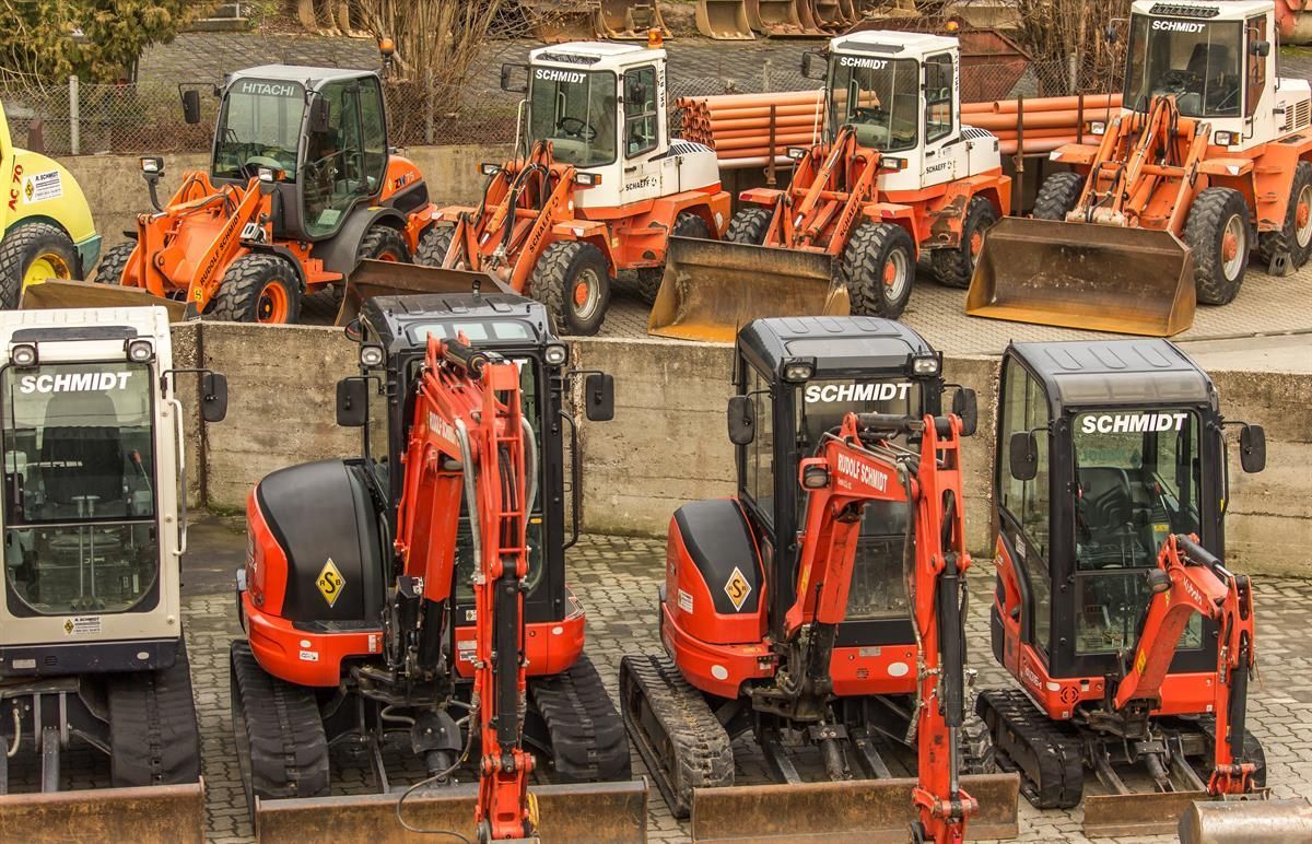 Eine Reihe landwirtschaftlicher Maschinen, darunter ein kleiner Bagger und ein Bulldozer