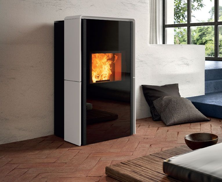 Poêle à granulés moderne noir et blanc avec une flamme visible dans un salon lumineux.