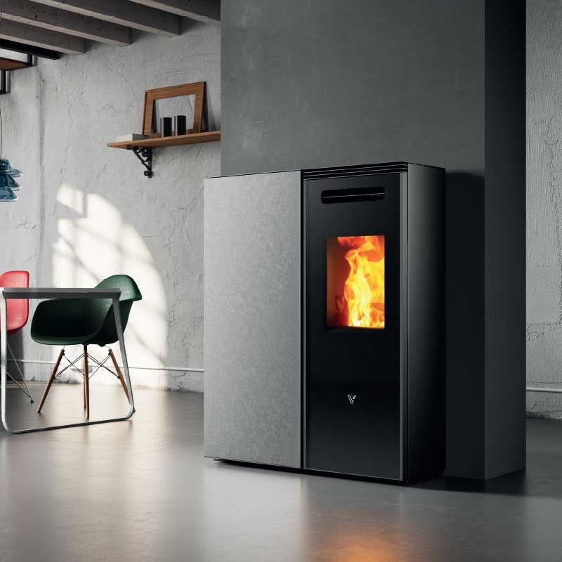 Poêle à granulés moderne noir et blanc avec une flamme visible dans un salon lumineux.