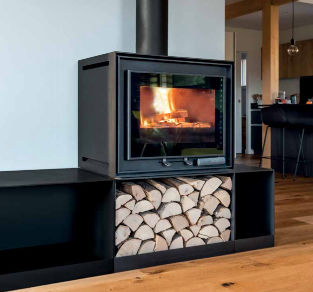 Poêle à bois noir moderne avec un feu qui brûle, encastré dans une niche murale avec des bûches empilées en dessous.