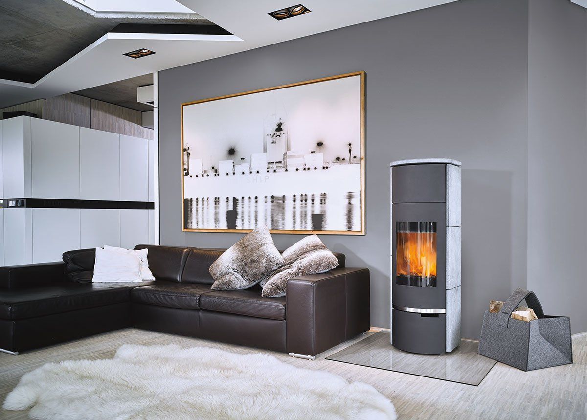 Salon moderne avec canapé noir, cheminée, tapis blanc et décoration minimaliste.