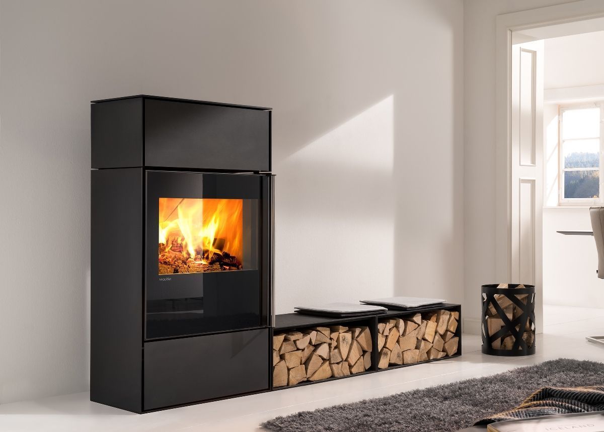 Poêle à bois noir moderne avec flammes visibles dans un salon minimaliste et lumineux.