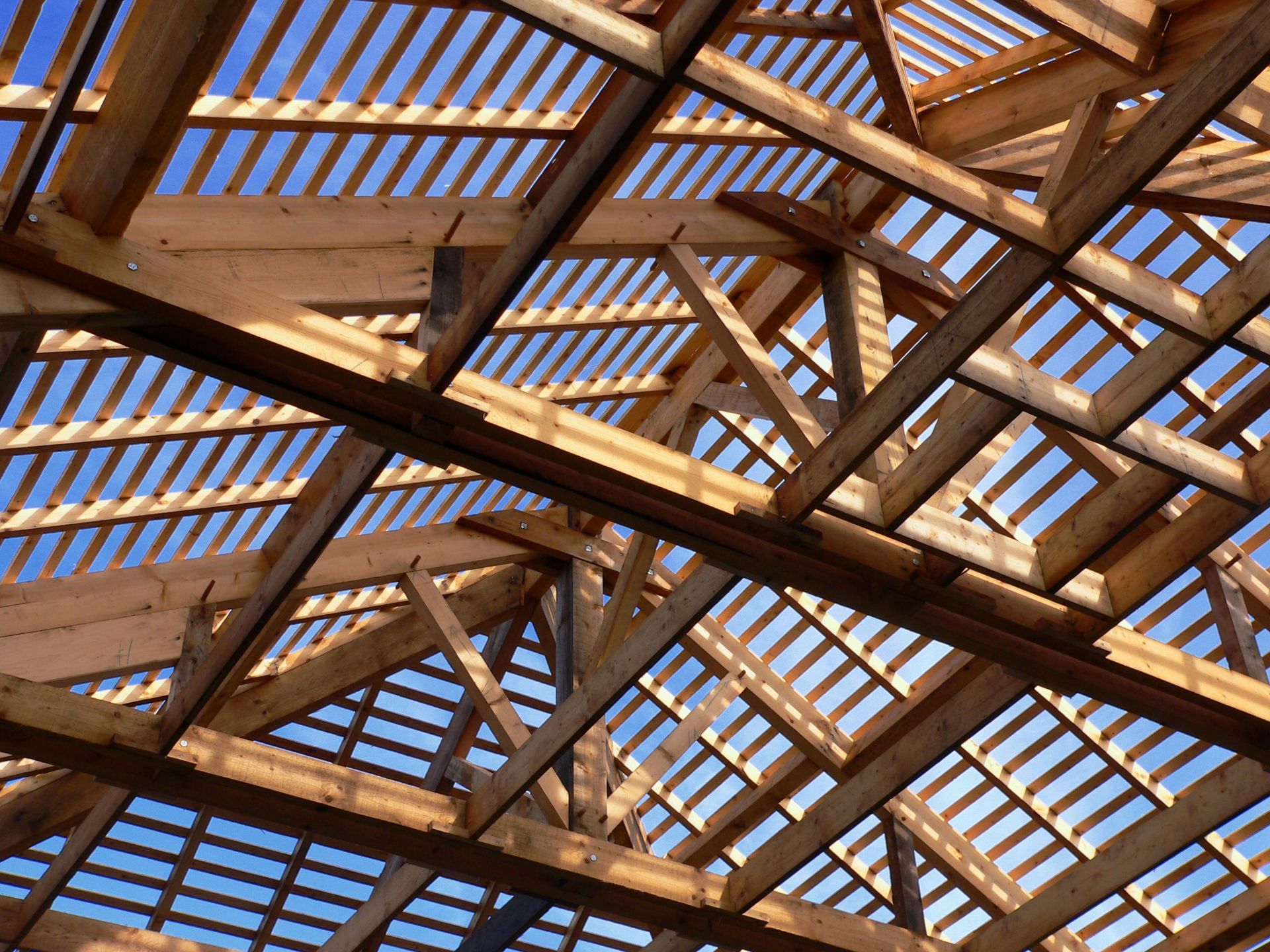 Fermes de toit en bois contre un ciel bleu, en construction.