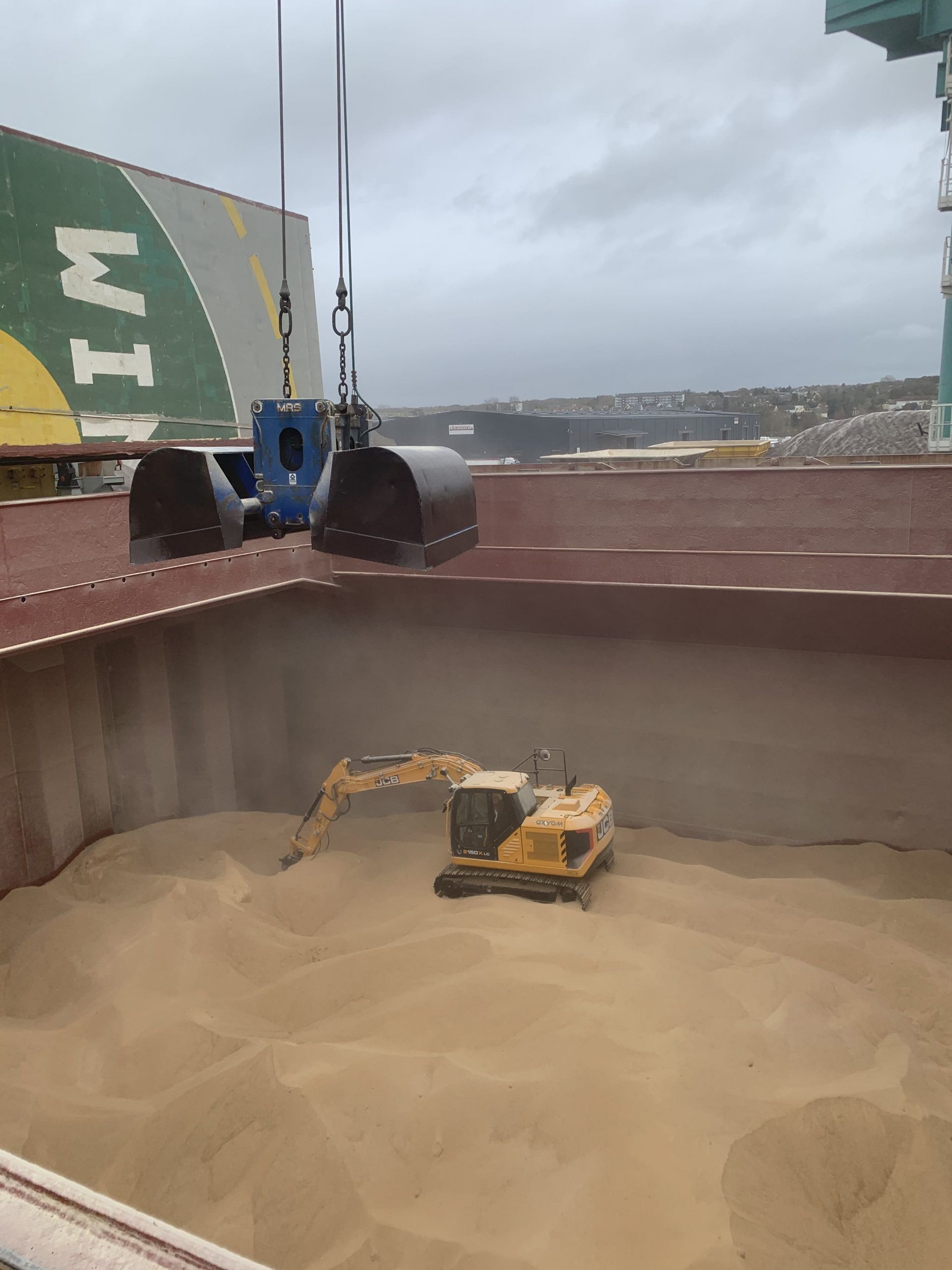 Grue et excavatrice chargeant du grain dans la cale.