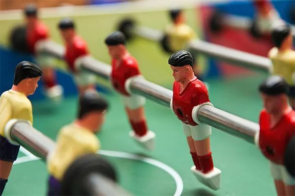 Un grupo de jugadores de fútbol está jugando un partido en una mesa.