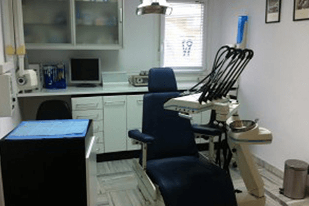 Un consultorio dental con un sillón dental y una computadora.