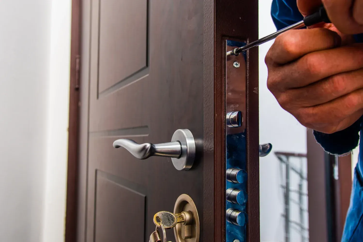 Un hombre está arreglando una puerta con un destornillador.