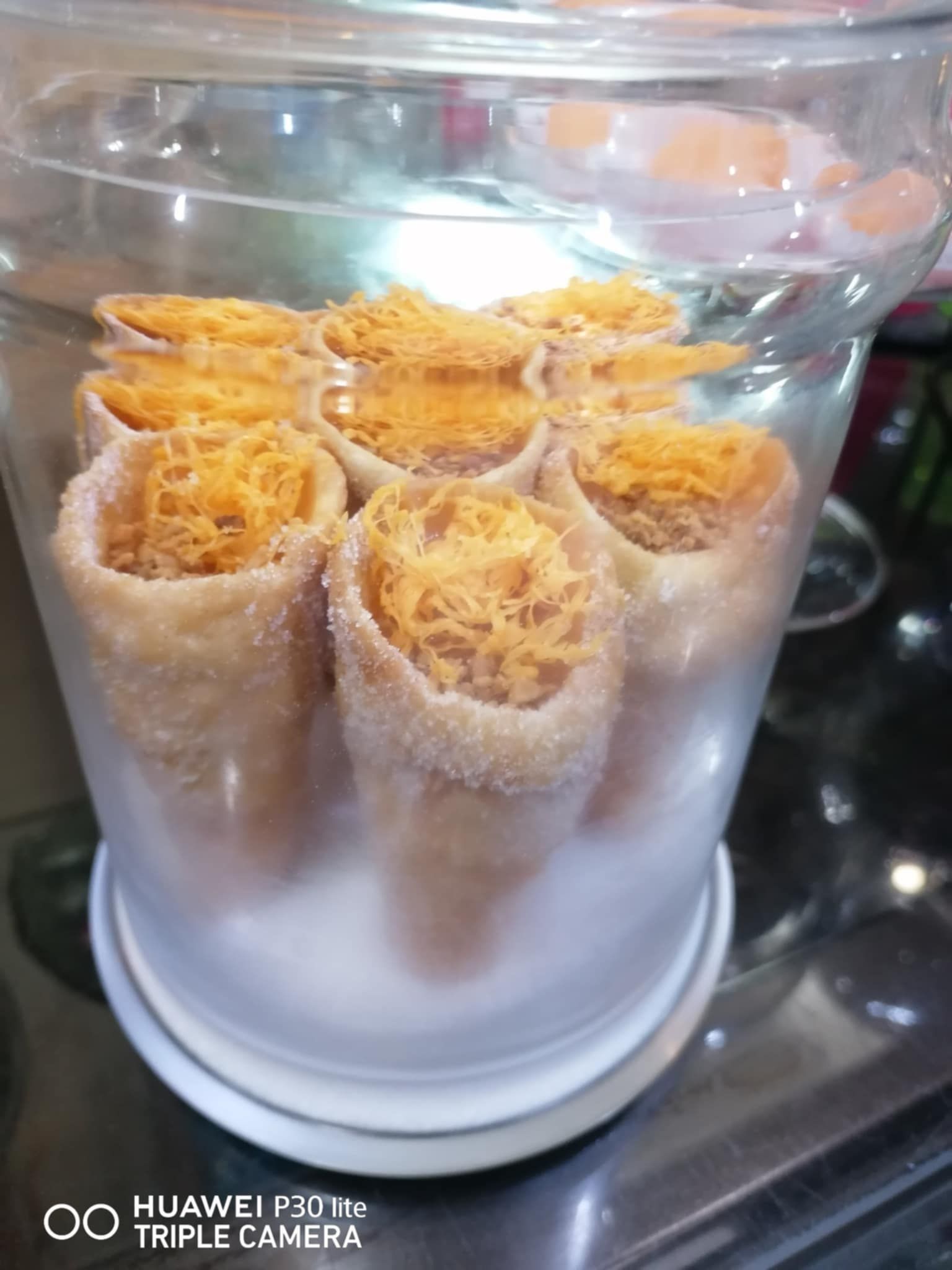 Um close de um recipiente de vidro cheio de comida sobre uma mesa.