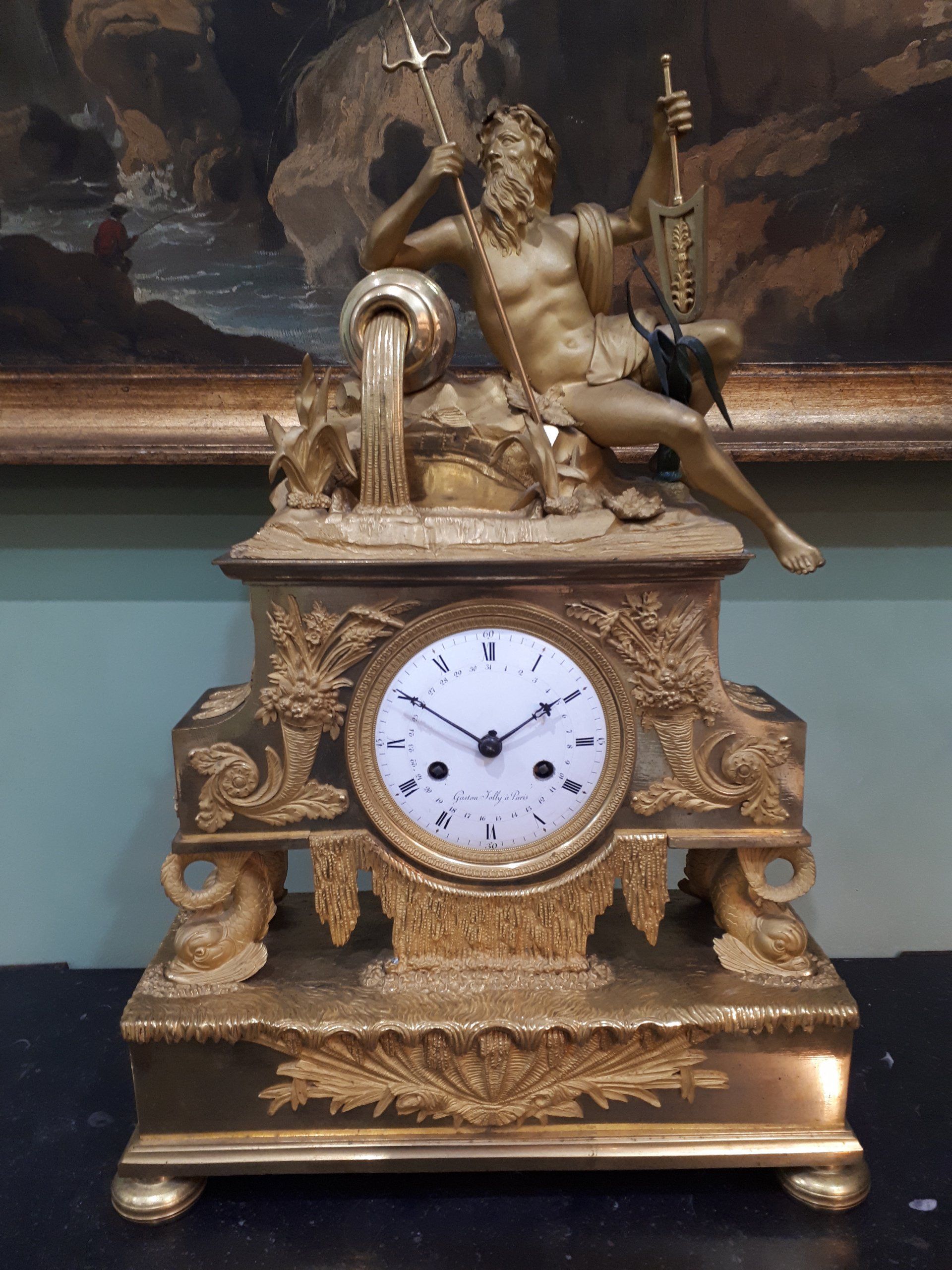 Horloge en métal doré avec une personne dessus