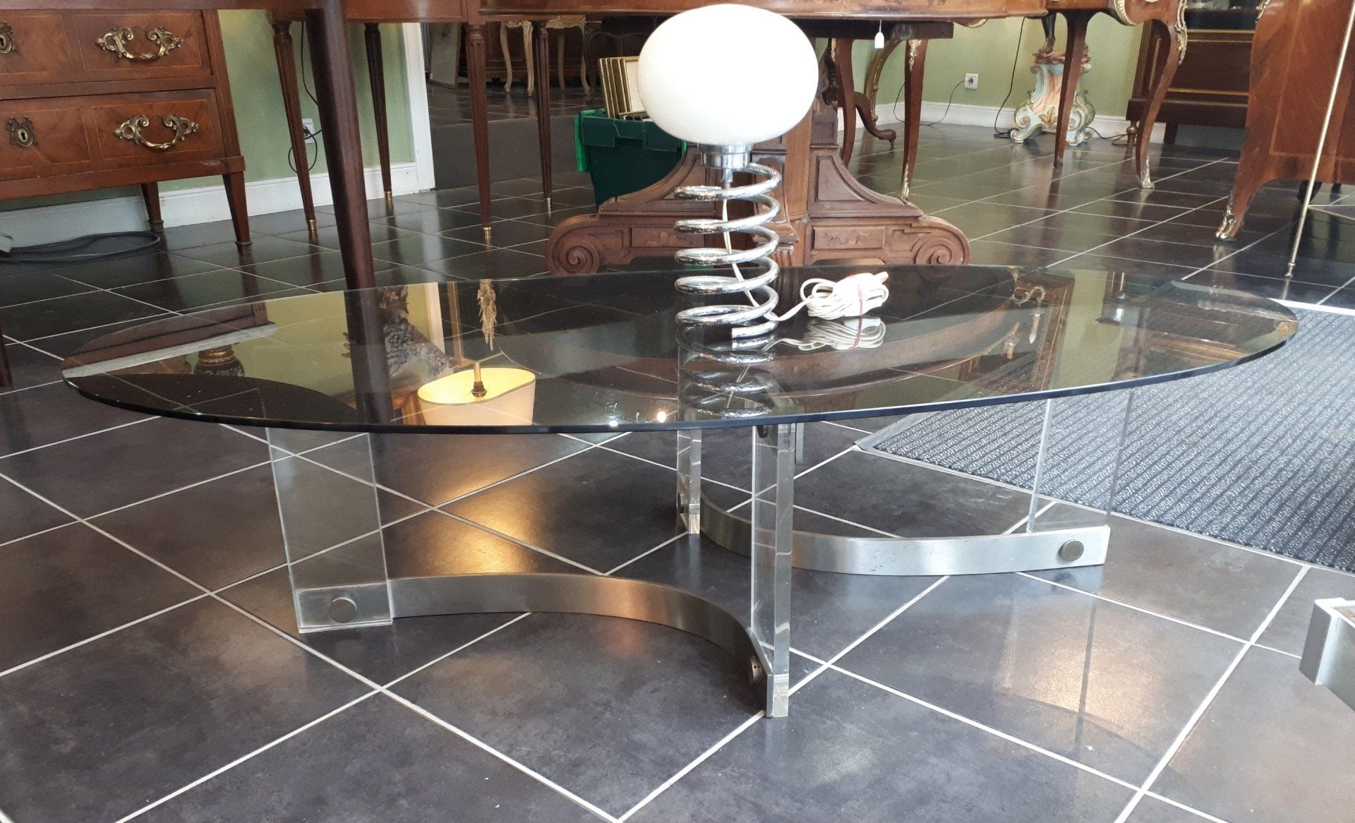 Table ovale en verre noir  et une lampe dessus