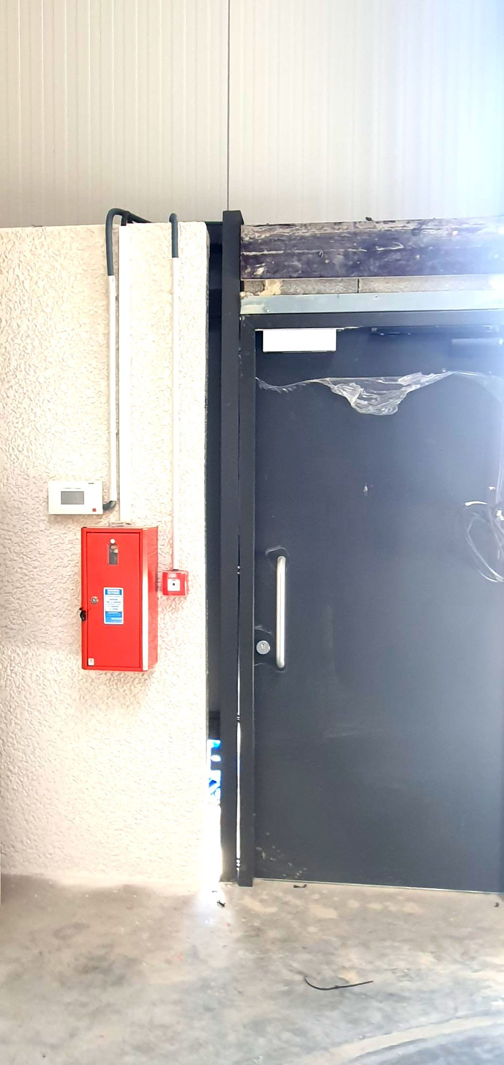 Porte noire à coté d'un boitier de commande
