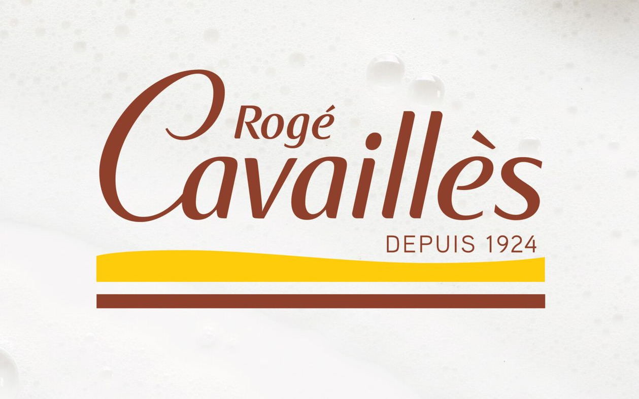 Logo Rogé Cavaillès, texte marron sur mousse blanche, avec bandes jaunes et marron,