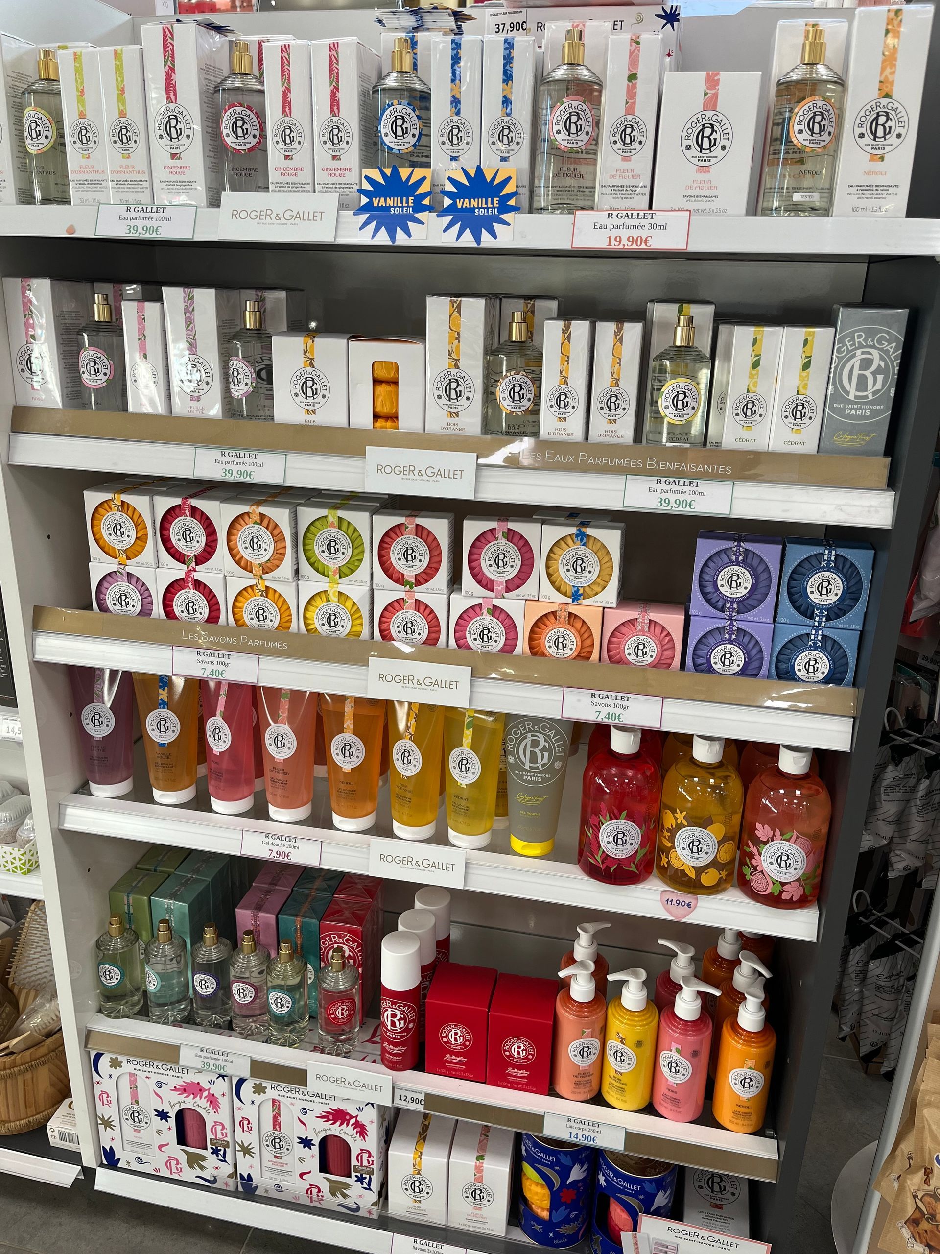 Des étagères remplies de produits cosmétiques variés : parfums, savons, lotions et gels dans des emballages colorés.