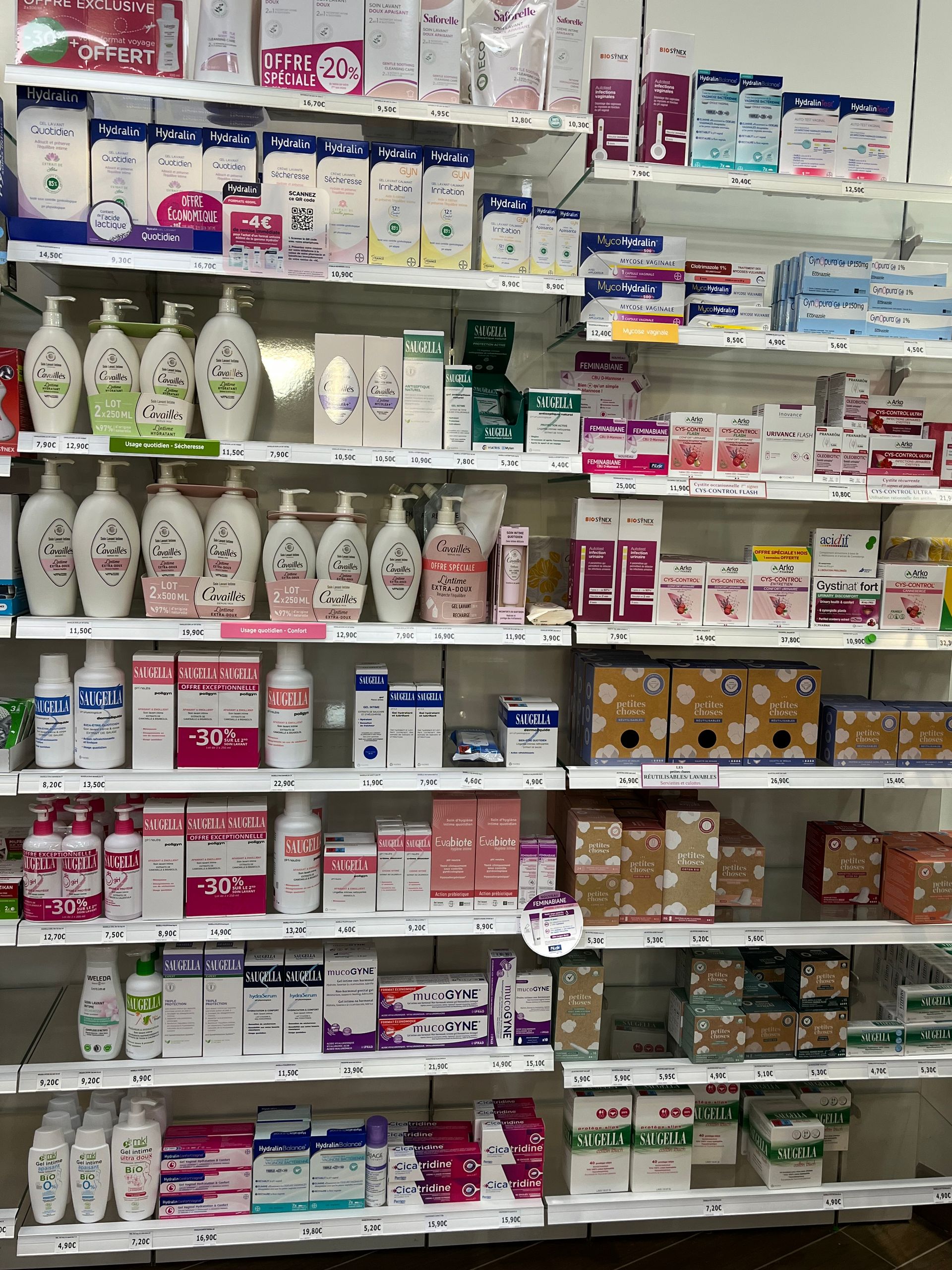 Étagères remplies de divers produits de santé et de beauté dans une pharmacie.