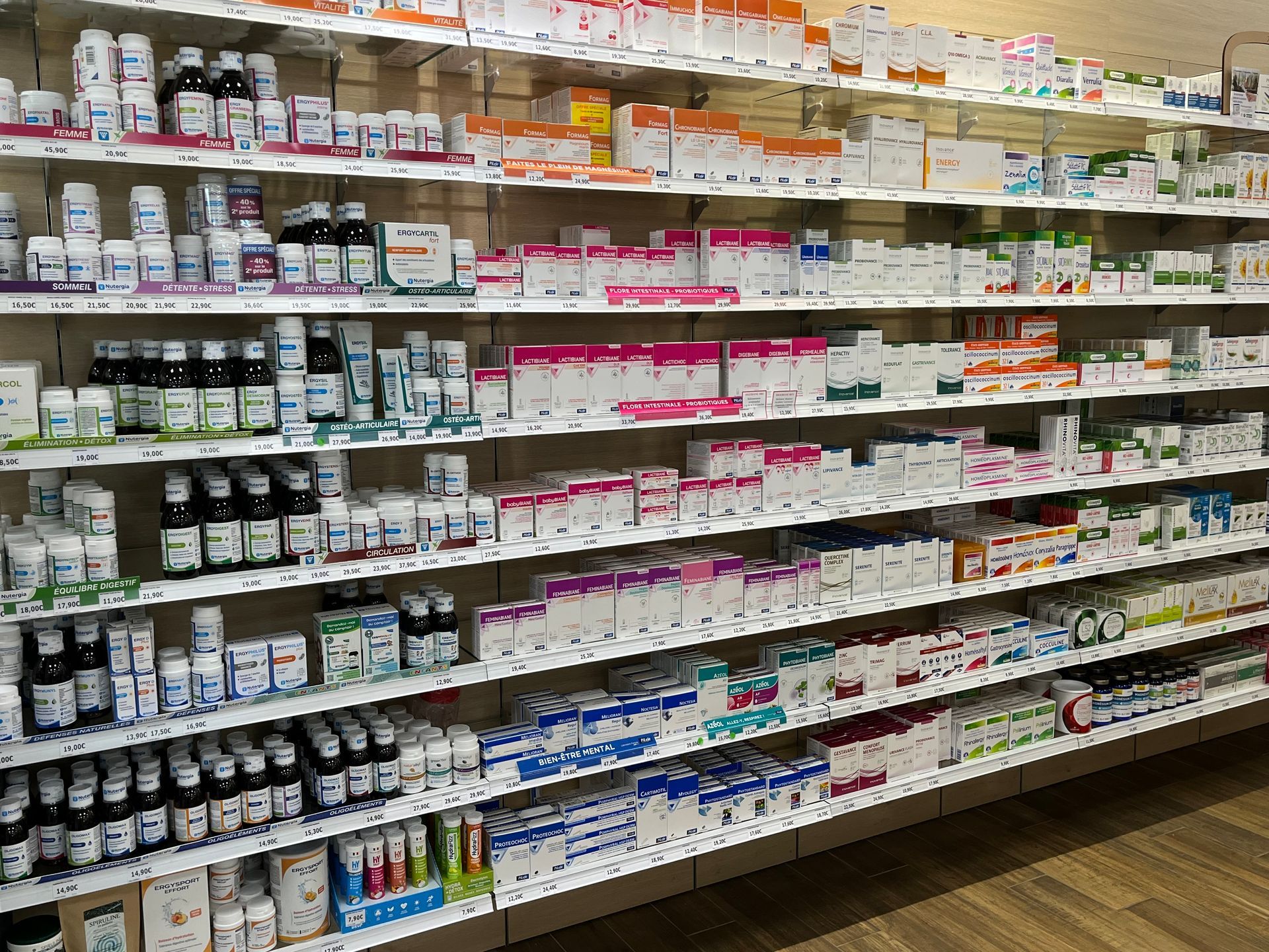 Étagères de flacons et de boîtes de médicaments dans une pharmacie.