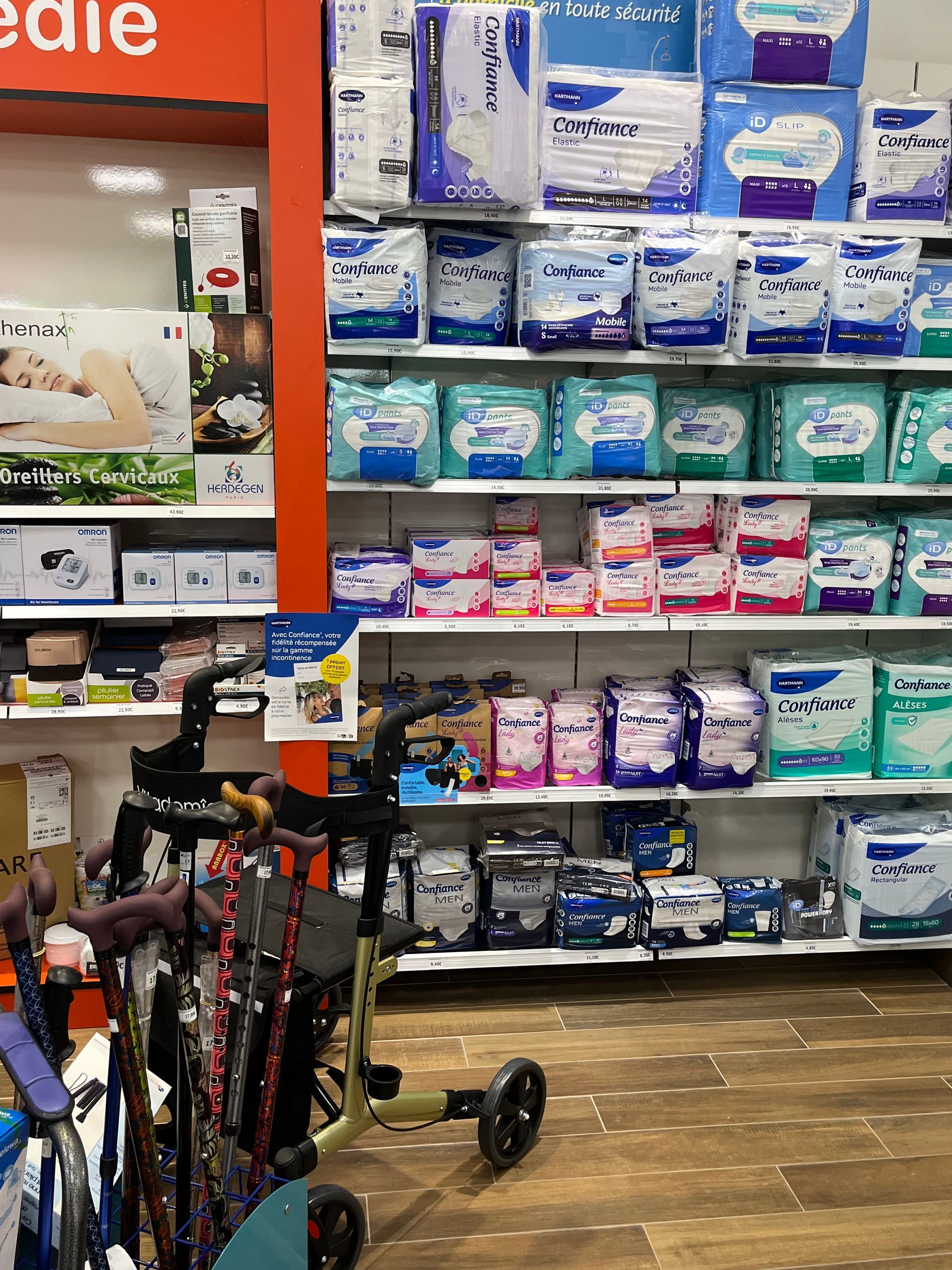 Étagères d'une pharmacie remplies de fournitures médicales et d'aides à la mobilité, notamment des déambulateurs et des cannes.