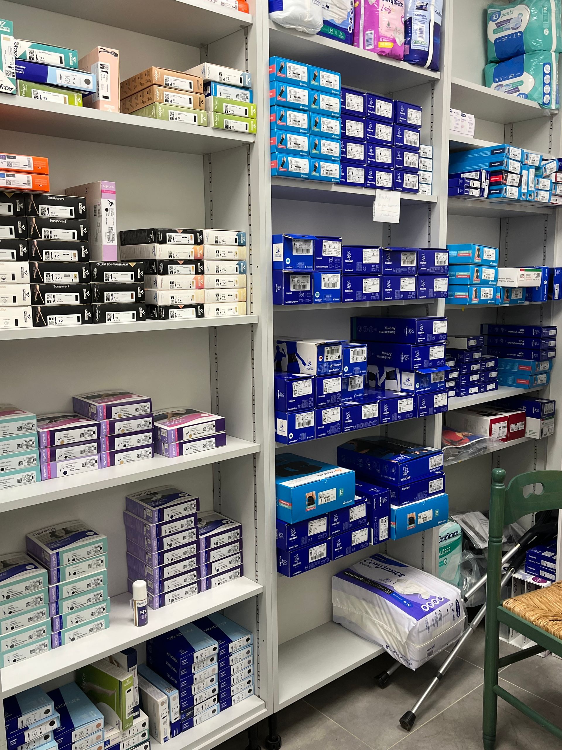 Des étagères remplies de nombreuses boîtes de fournitures médicales dans une pharmacie.