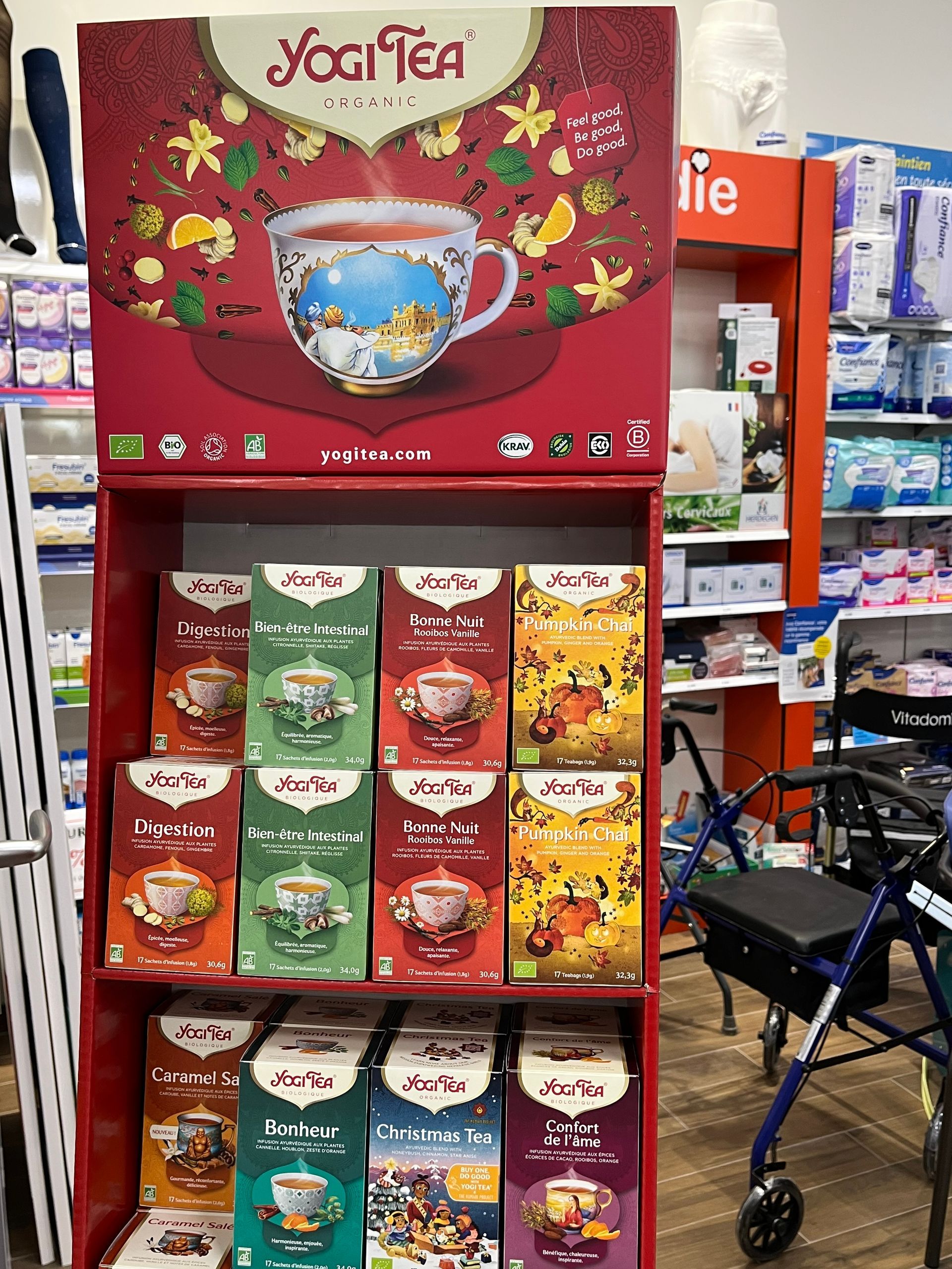 Présentoir Yogi Tea dans un magasin, étagères rouges avec boîtes de thé, panneau supérieur avec graphique de tasse.