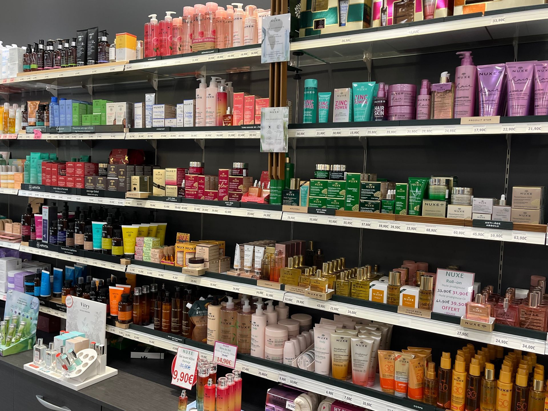 Des étagères remplies de divers produits de beauté et de soins capillaires colorés dans un magasin.